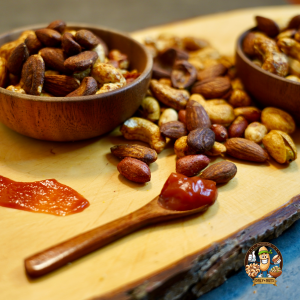 BBQ-würzige Nussmischung in rustikalen Holzschalen, begleitet von einer frischen roten Chili. Diese köstliche Kombination aus Cashews, Mandeln und weiteren Premium-Nüssen wird mit rauchigen BBQ-Gewürzen verfeinert. Der perfekte Snack für Liebhaber von herzhaften, würzigen Genüssen. Ideal für Partys, unterwegs oder als schmackhafter Genussmoment. #BBQGenuss #WürzigeNüsse #RauchigerSnack #GesundeKnabbereien #OnlyNuts